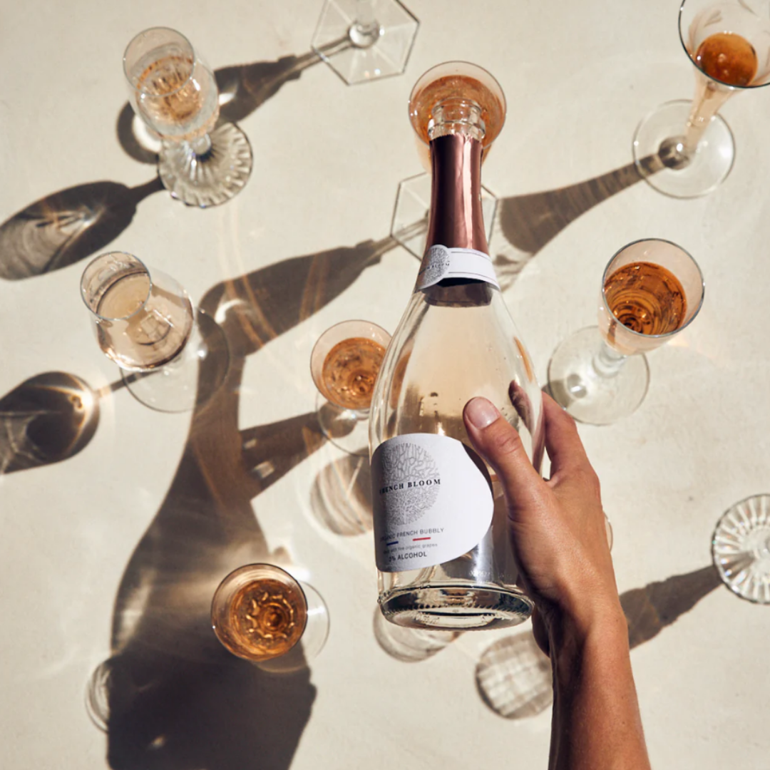 Fles French Bloom Le Rosé alcoholvrij, 75cl, met een elegant drankje in een wijnglas op een witte achtergrond.